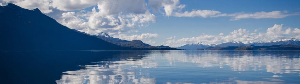 Himmel som reflekteras över en spegelblank sjö
